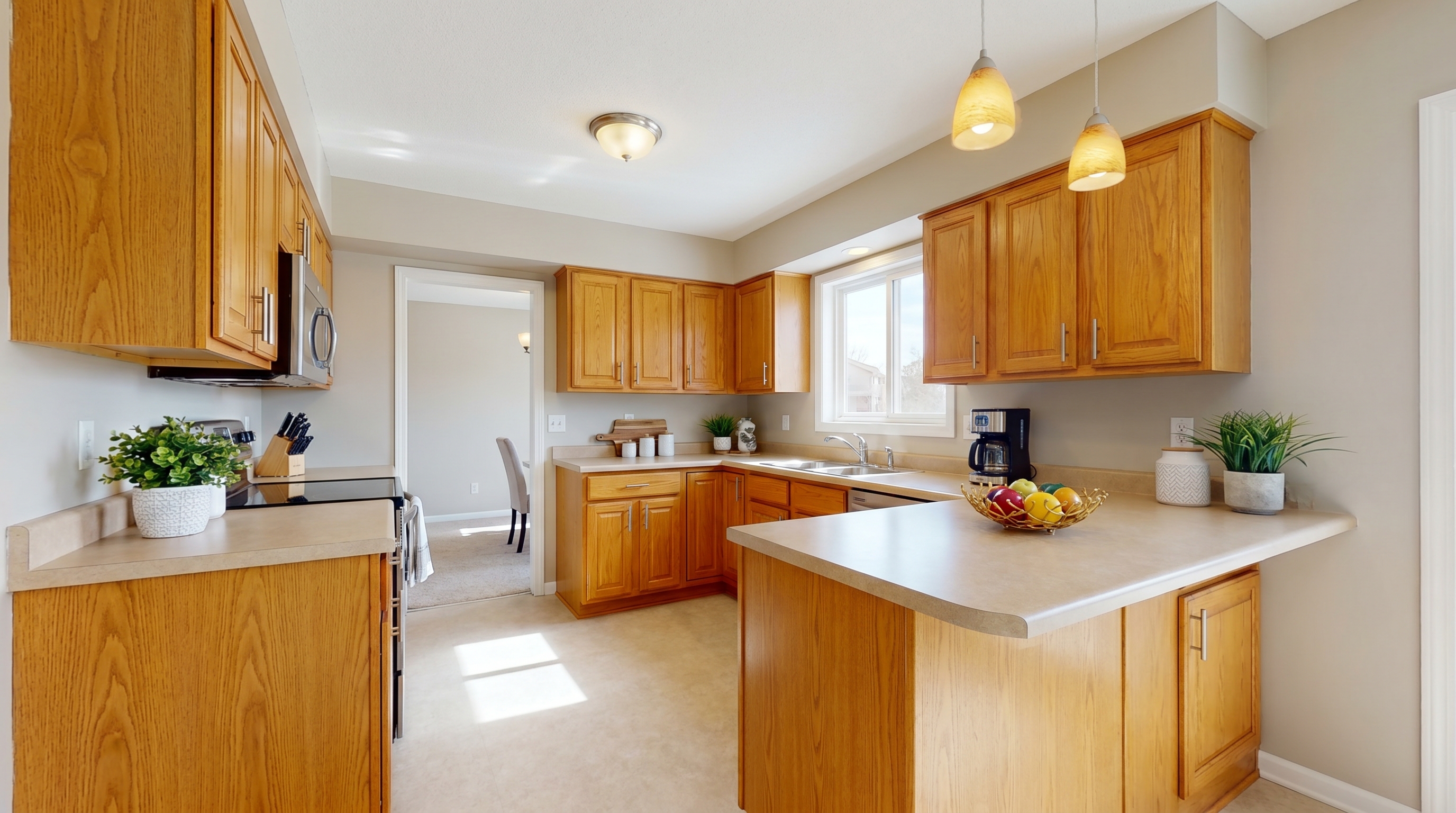 Pre-sale kitchen refresh with honey oak cabinets, SW Accessible Beige walls, white trim, and new brushed nickel bar pulls